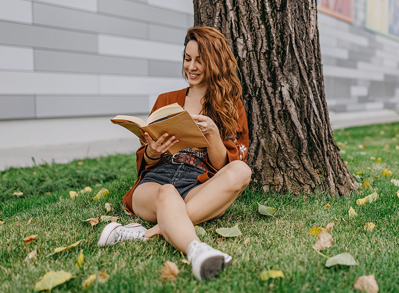 young woman reading outside